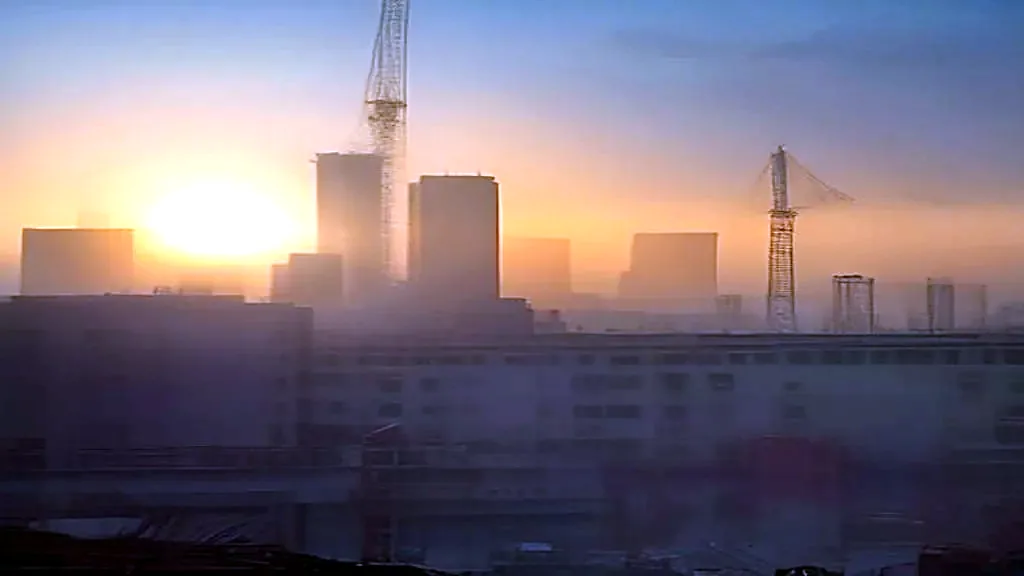 A construction site with a tower crane at golden hour